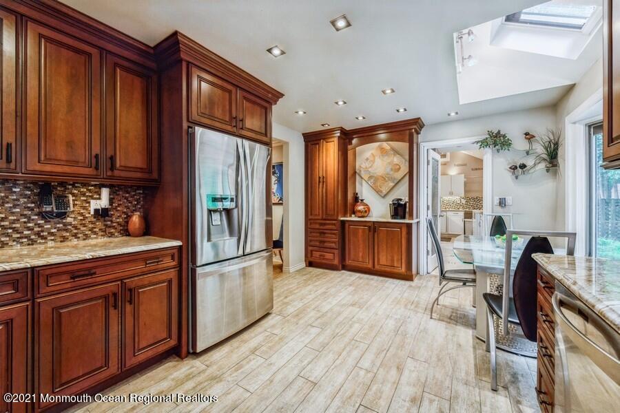 57 Millay Road Morganville, NJ 07751 - Photo 16 of 46 a kitchen with granite countertop wooden floors and stainless steel appliances