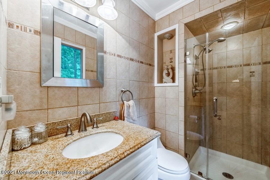57 Millay Road Morganville, NJ 07751 - Photo 22 of 46 a bathroom with a granite countertop sink toilet a mirror and shower