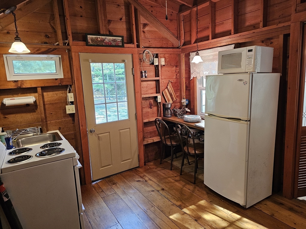 1937 State Hwy Route, Unit 8 Wellfleet, MA 02667 - Photo 7 of 17 a view of a kitchen with fridge and wooden floor