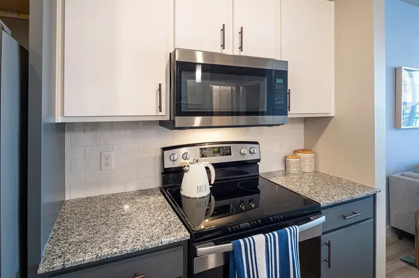 a kitchen with granite countertop a stove and a microwave