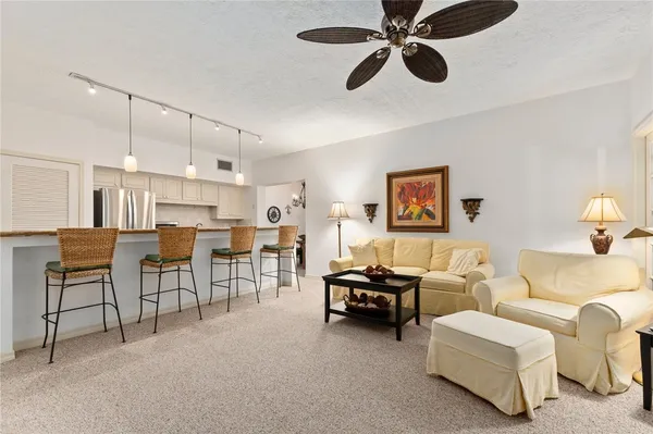 a view of a dining room with furniture a chandelier and a window