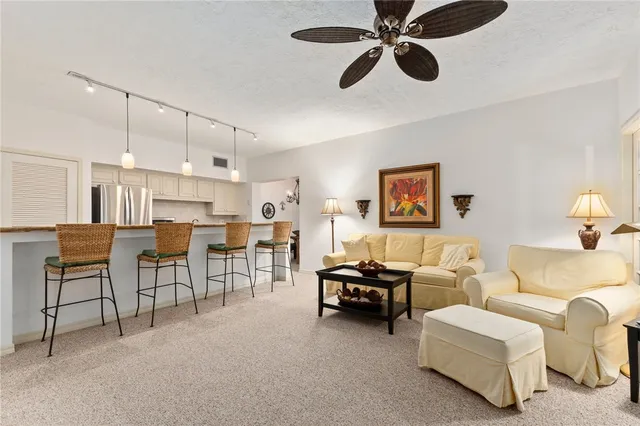 a view of a dining room with furniture a chandelier and a window