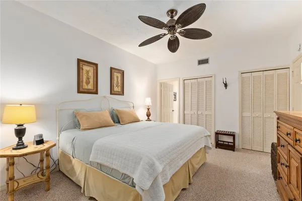 a spacious bedroom with a bed and a chandelier