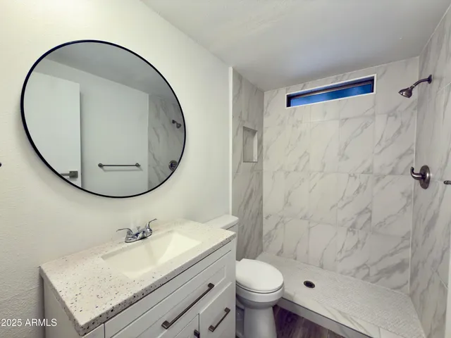 a bathroom with a granite countertop sink and a mirror