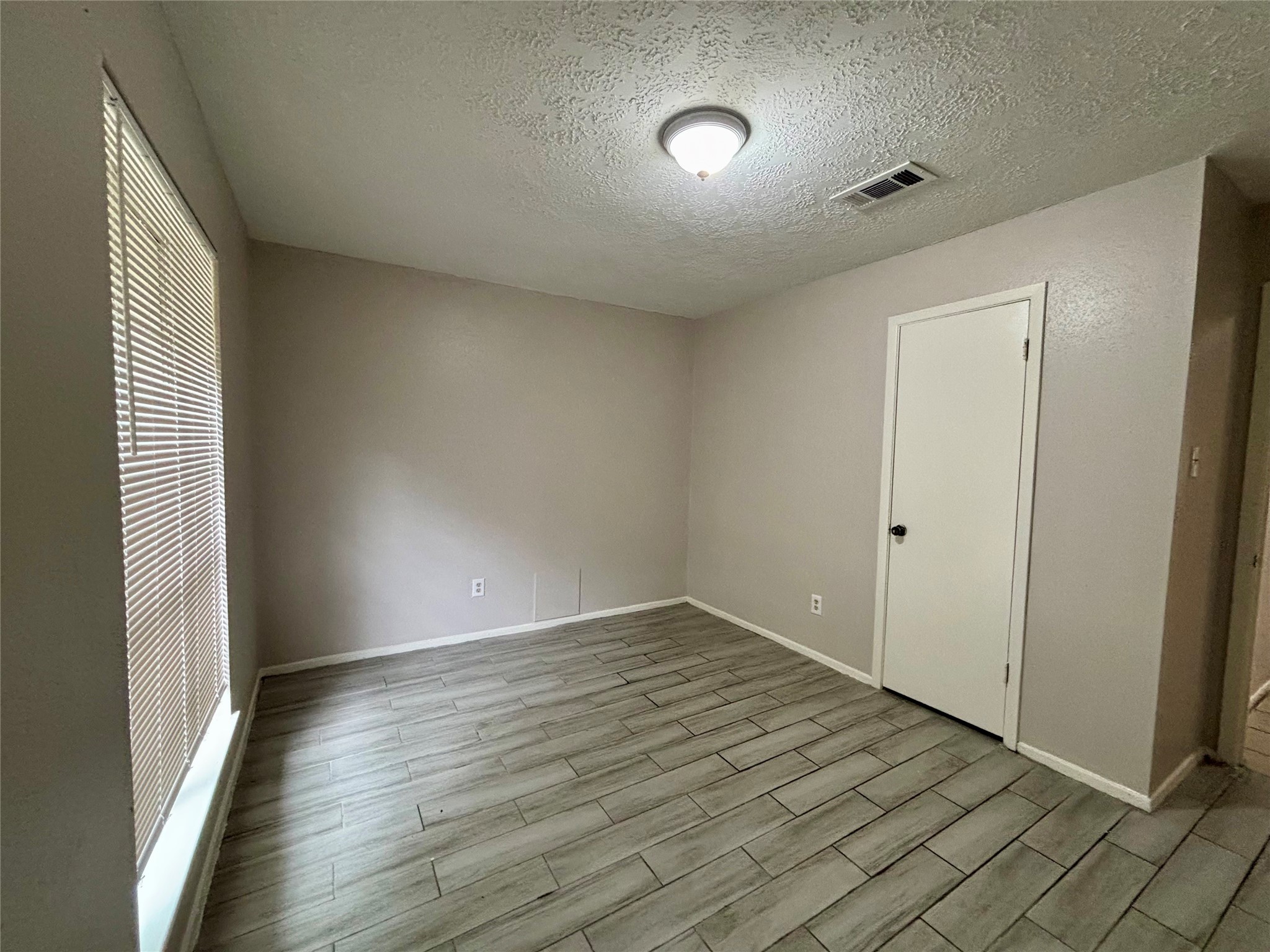4426 Hirschfield Road Spring, TX 77373 - Photo 13 of 20 an empty room with wooden floor and windows