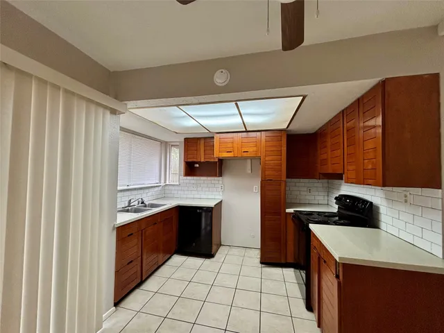 a kitchen with a sink a stove top oven and cabinets