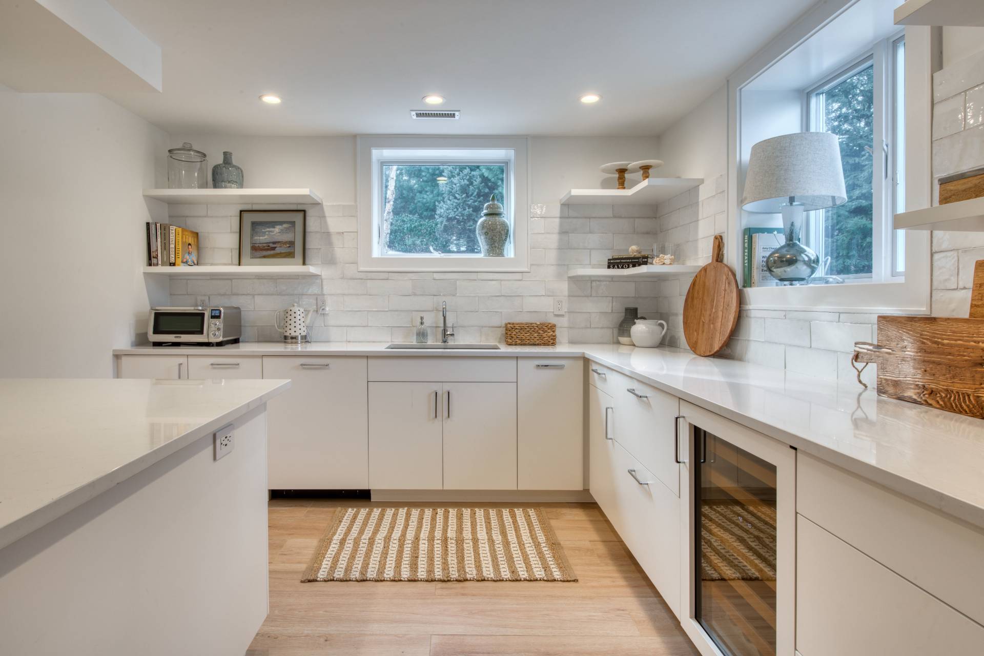 30 Springwood Way East Hampton, NY 11937 - Photo 22 of 32 a kitchen with a sink dishwasher a stove and white cabinets with wooden floor