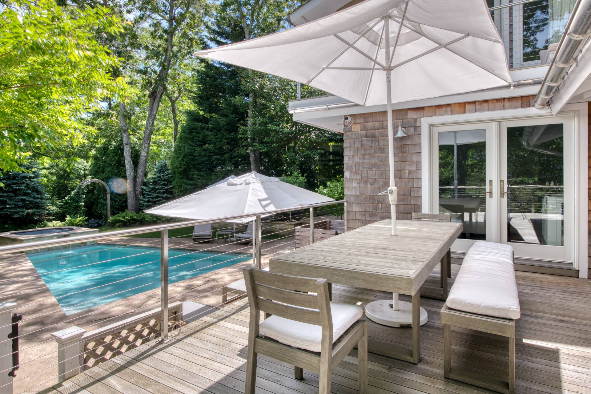 30 Springwood Way East Hampton, NY 11937 - Photo 26 of 32 a view of a patio with table and chairs under an umbrella