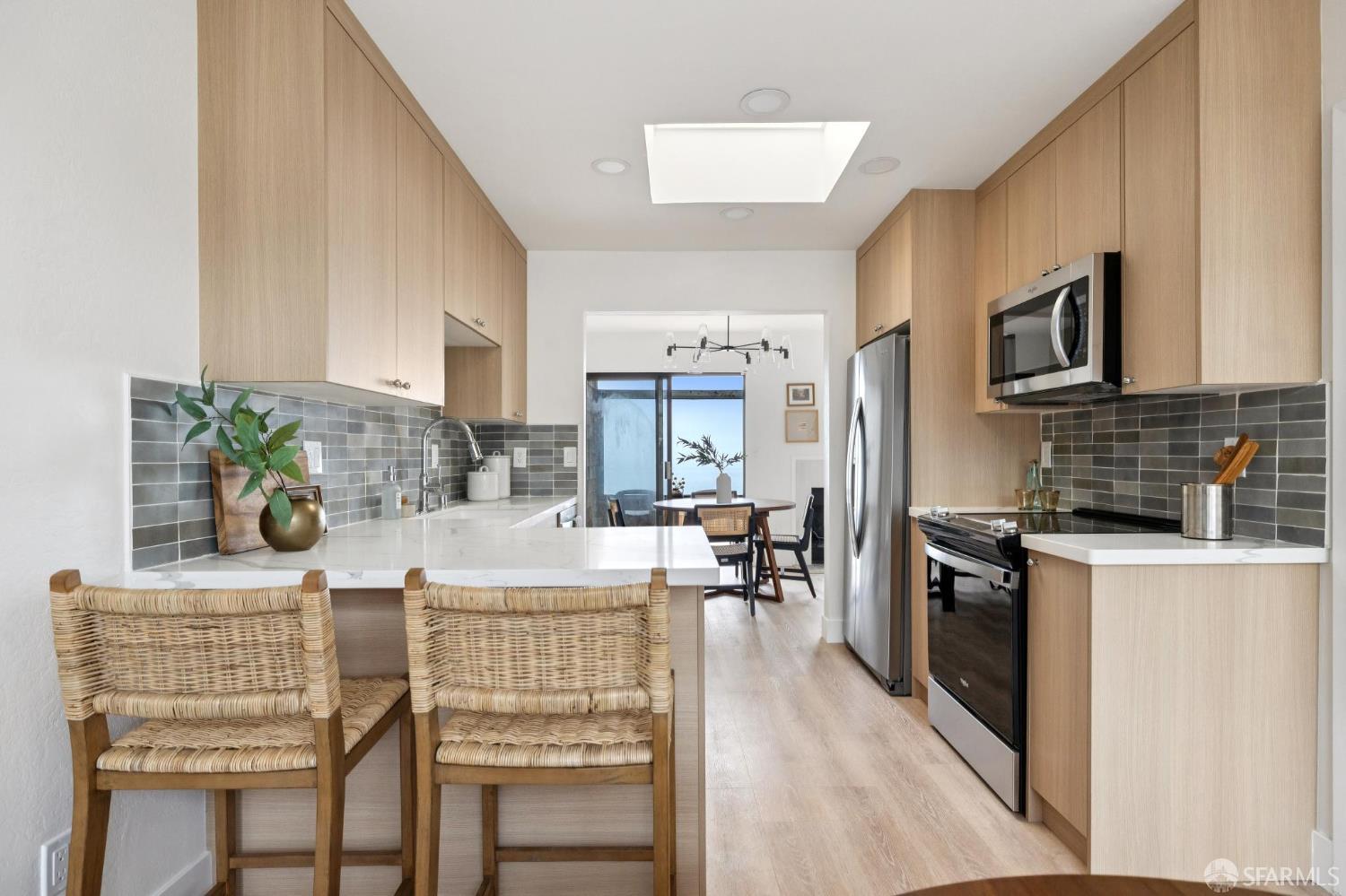 274 Beachview Avenue, Unit 16 Pacifica, CA 94044 - Photo 33 of 81 a kitchen with stainless steel appliances kitchen island granite countertop a stove a sink dishwasher and white cabinets with wooden floor