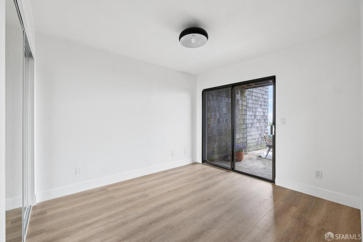 274 Beachview Avenue, Unit 16 Pacifica, CA 94044 - Photo 47 of 81 a view of an empty room with wooden floor and a window