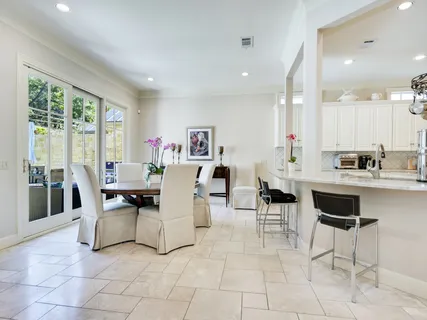 a living room with couches and kitchen view with wooden floor