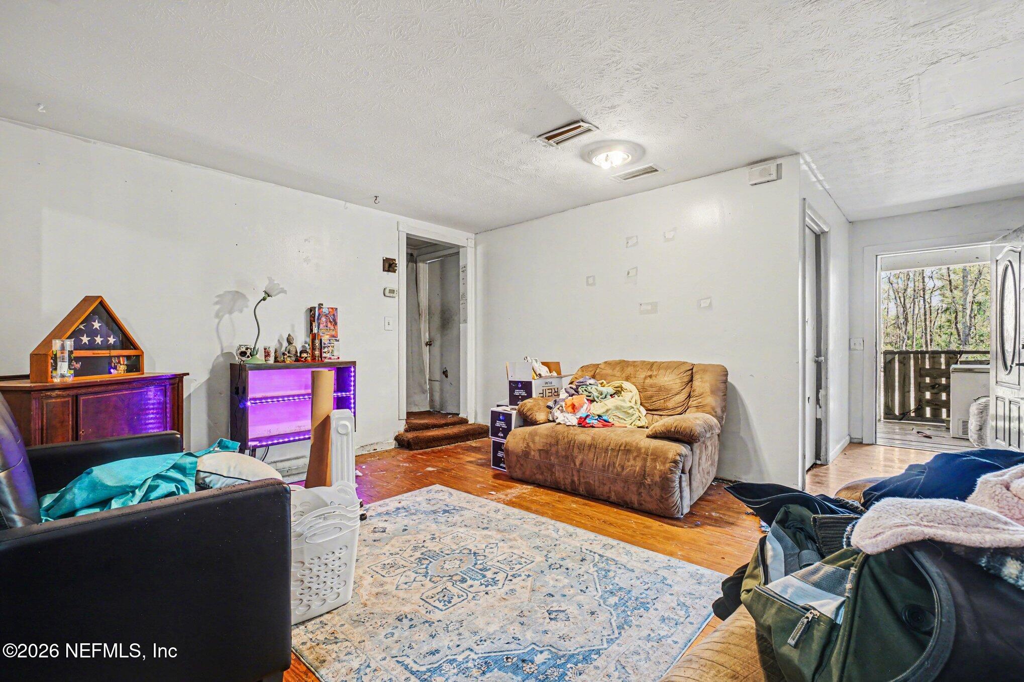 3390 Lannie Road Jacksonville, FL 32218 - Photo 2 of 18 a living room with furniture and a flat screen tv