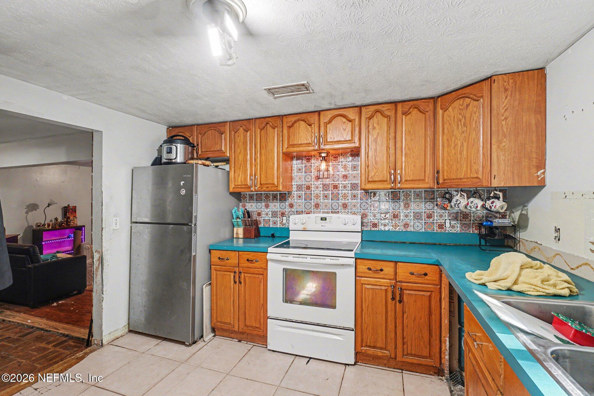 3390 Lannie Road Jacksonville, FL 32218 - Photo 4 of 18 a kitchen with stainless steel appliances granite countertop a refrigerator and a stove top oven