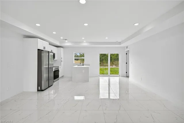 a view of an empty room with a fireplace and a window
