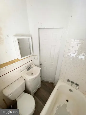 a white toilet sitting next to a bath tub