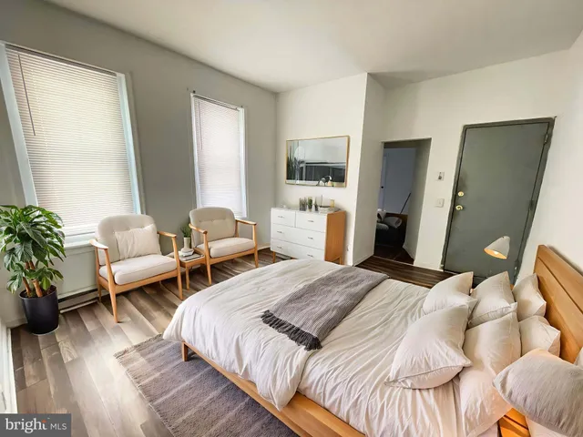 a bedroom with two beds and potted plant on the dresser