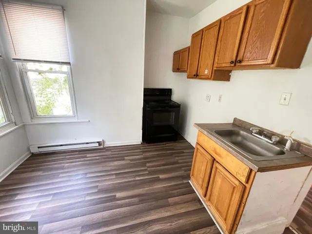 a kitchen with wooden cabinets and a stove top oven