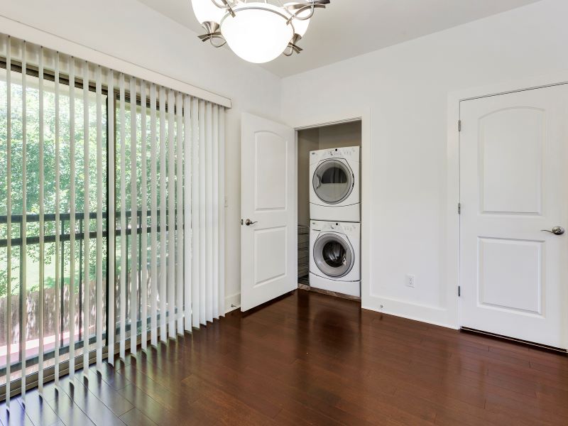 13420 Lyndhurst Street, Unit 308 Austin, TX 78717 - Photo 15 of 25 Laundry area featuring a chandelier, dark wood-style floors, and estacked washer and dryer