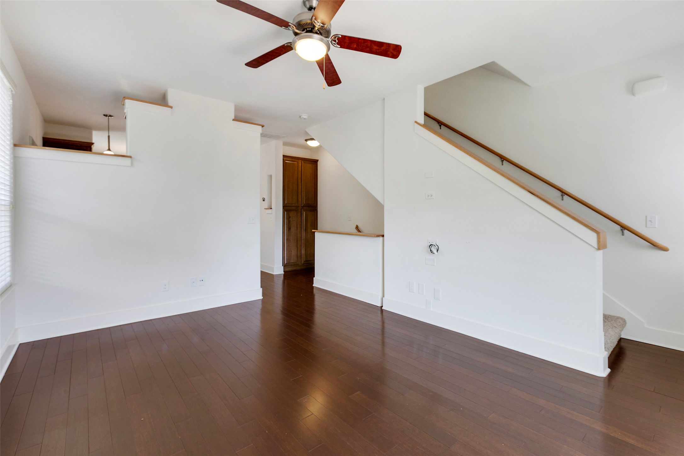 13420 Lyndhurst Street, Unit 308 Austin, TX 78717 - Photo 16 of 25 Unfurnished living room featuring dark wood-style floors, stairway, and a ceiling fan