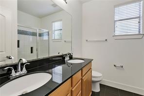 13420 Lyndhurst Street, Unit 308 Austin, TX 78717 - Photo 18 of 25 Bathroom with a shower stall, double vanity, and dark tile patterned floors
