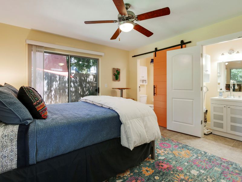 13420 Lyndhurst Street, Unit 308 Austin, TX 78717 - Photo 6 of 25 Bedroom with a barn door, ensuite bathroom, access to exterior, and ceiling fan