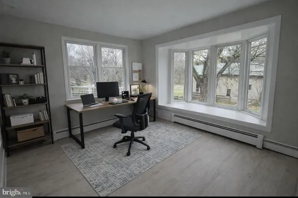 a view of a workspace with furniture and a window