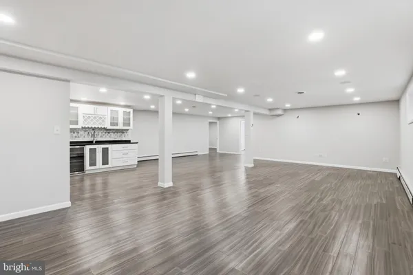a view of a room with wooden floors and kitchen view
