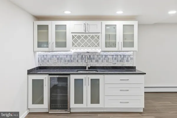 a view of kitchen with granite countertop white cabinets and window