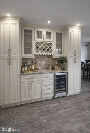 a kitchen with granite countertop a refrigerator and cabinets