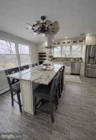 a kitchen with kitchen island a stove a table and chairs in it