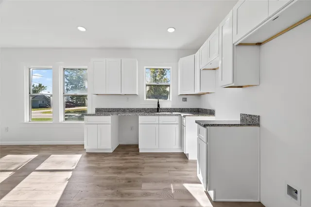 a kitchen with granite countertop a stove a sink and a microwave