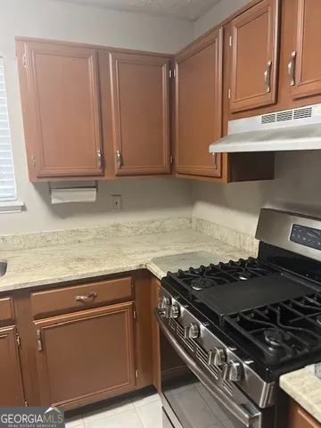 a kitchen with granite countertop a stove and a sink