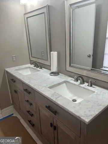 a bathroom with a granite countertop sink and a mirror