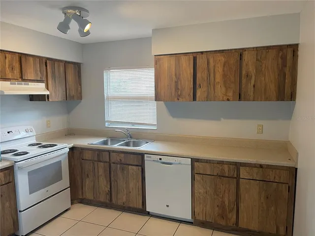a kitchen with a stove sink and cabinets
