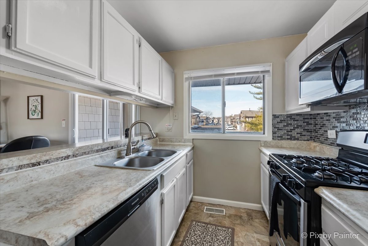 6207 Kit Carson Drive, Unit 6207 Hanover Park, IL 60133 - Photo 7 of 24 a kitchen with granite countertop a sink stove and cabinets