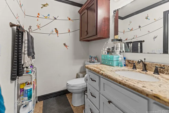a bathroom with a granite countertop sink a toilet and a mirror