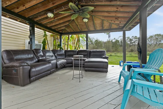 a living room with patio furniture and a floor to ceiling window