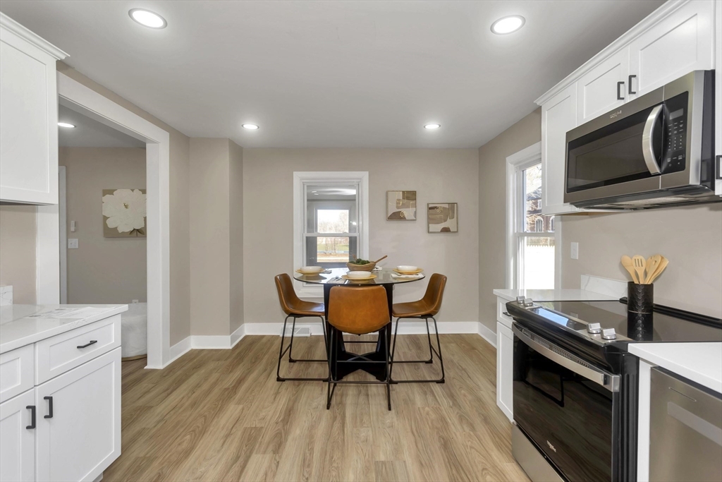 3 Norfolk Street Springfield, MA 01109 - Photo 16 of 42 a kitchen with stainless steel appliances granite countertop a stove top oven a sink dishwasher a dining table and chairs with wooden floor