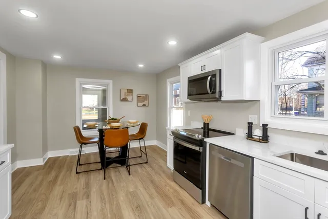 a kitchen with stainless steel appliances granite countertop a stove a sink a microwave a refrigerator and cabinets