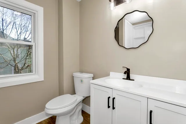 a bathroom with a toilet sink and mirror