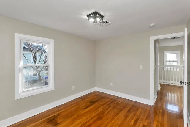 a view of empty room with wooden floor