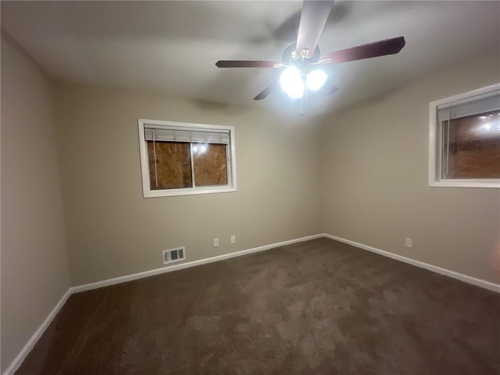 2785 Battle Forrest Drive Decatur, GA 30034 - Photo 12 of 16 an empty room with a chandelier fan and windows
