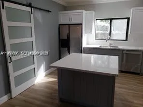 a kitchen with a sink a refrigerator and window