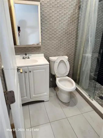 a white toilet sitting next to a bathroom sink