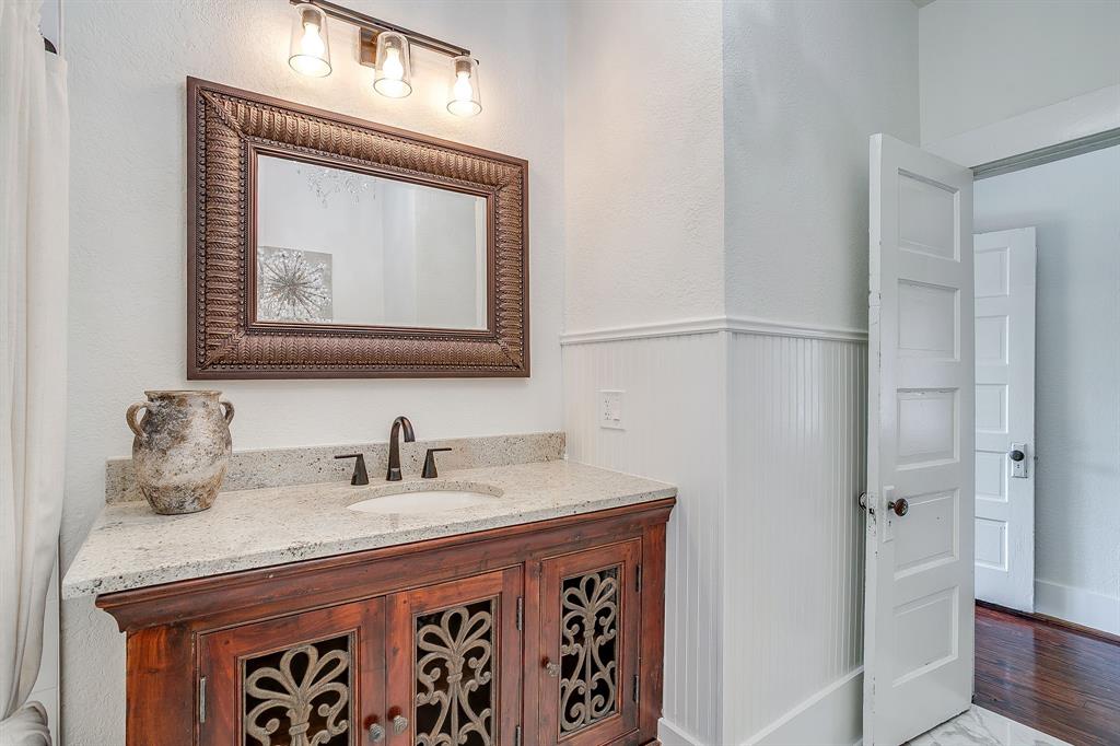 116 East Akard Street Weatherford, TX 76086 - Photo 20 of 32 a bathroom with a granite countertop sink a mirror and a shower