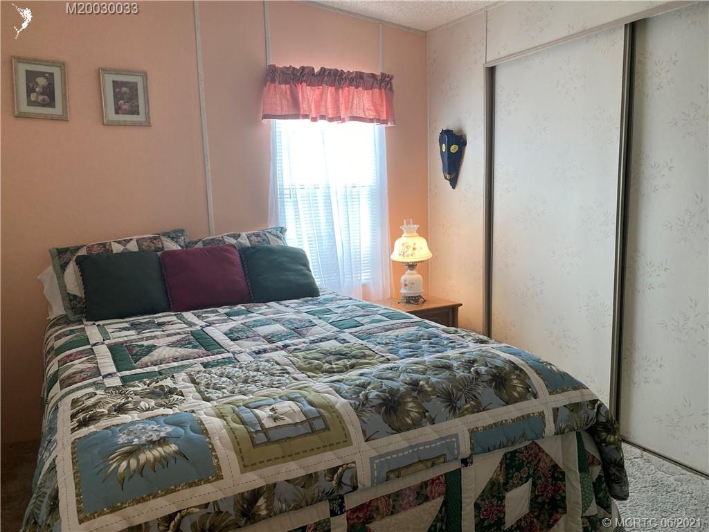 4718 Southeast Balsawood Terrace Stuart, FL 34997 - Photo 19 of 25 a bedroom with a bed and wooden floor