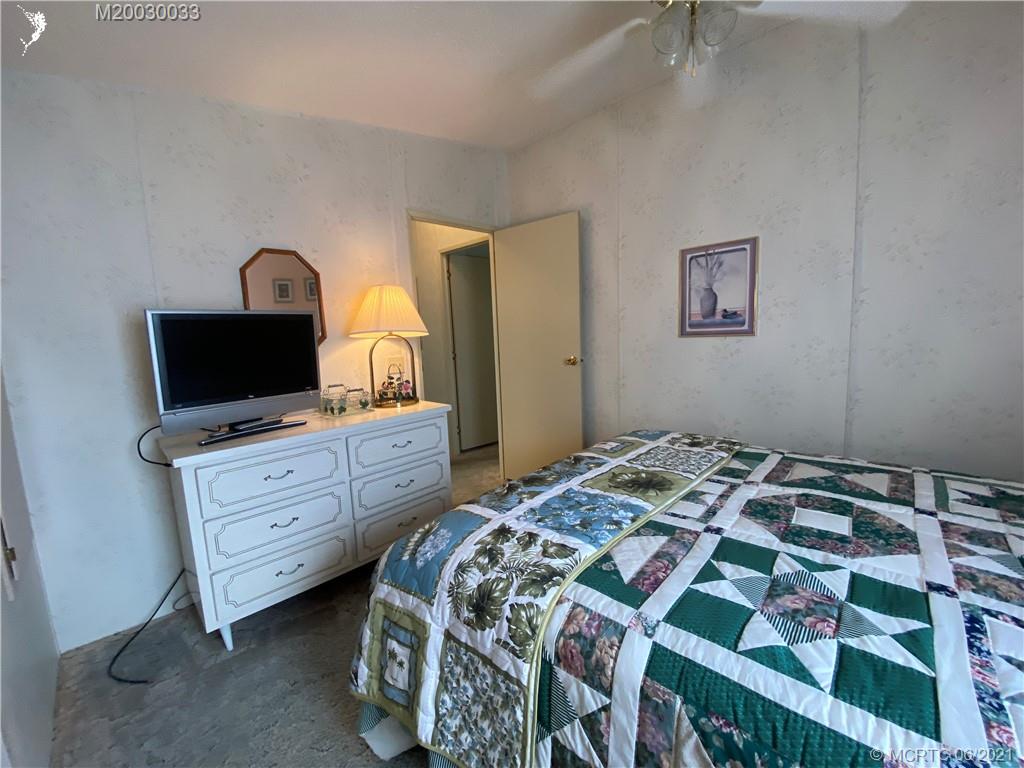 4718 Southeast Balsawood Terrace Stuart, FL 34997 - Photo 20 of 25 a bedroom with a bed and a flat tv screen on dresser