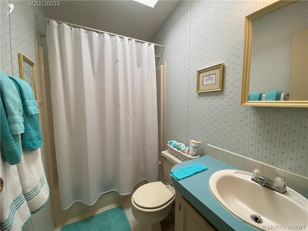 4718 Southeast Balsawood Terrace Stuart, FL 34997 - Photo 22 of 25 a bathroom with a sink toilet and mirror