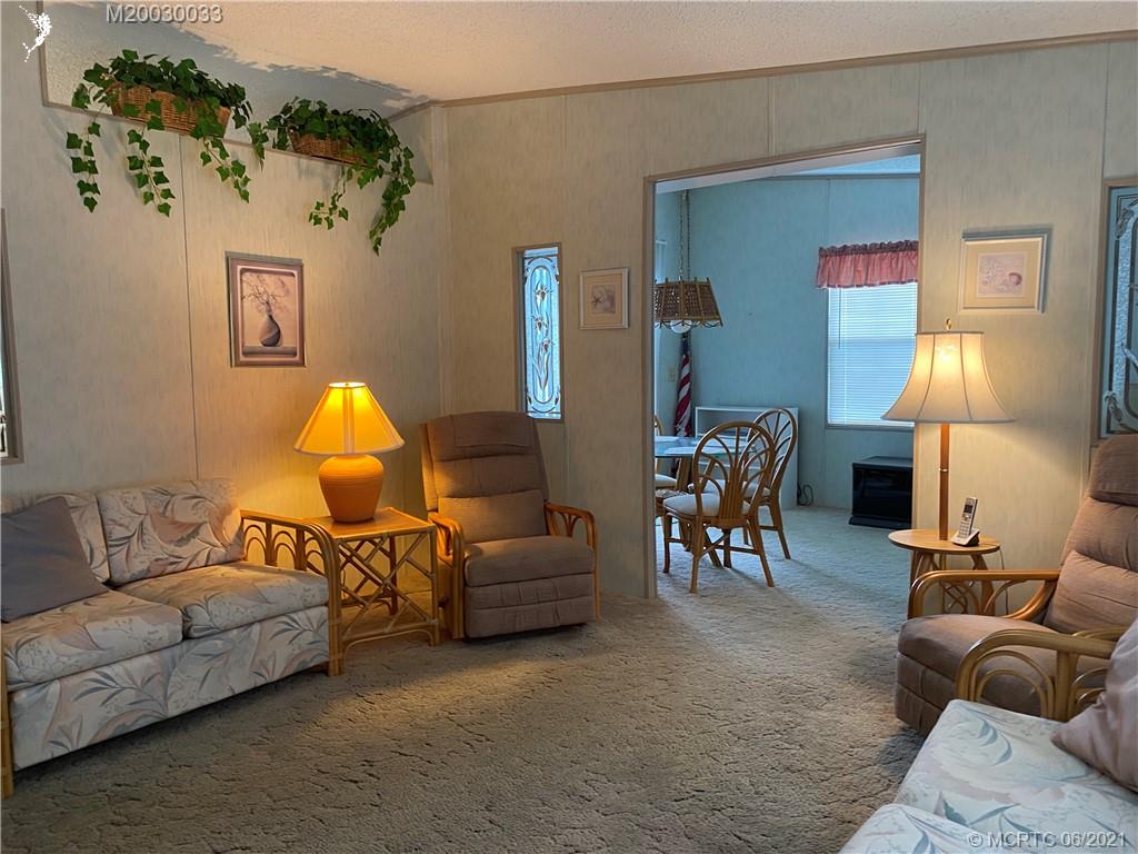 4718 Southeast Balsawood Terrace Stuart, FL 34997 - Photo 4 of 25 a living room with furniture and a lamp