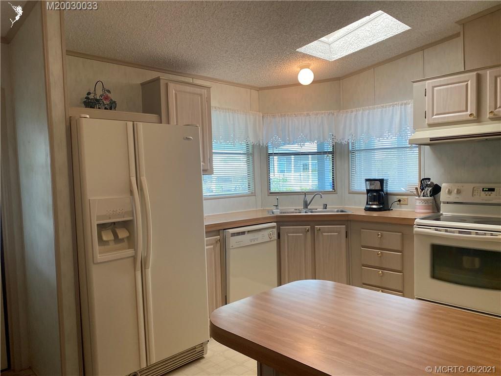 4718 Southeast Balsawood Terrace Stuart, FL 34997 - Photo 9 of 25 a kitchen with stainless steel appliances a refrigerator sink and cabinets